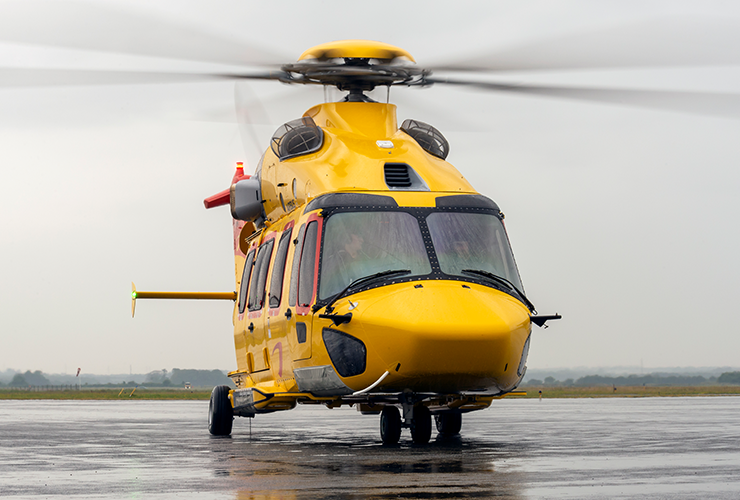 Yellow helicopter on paved ground